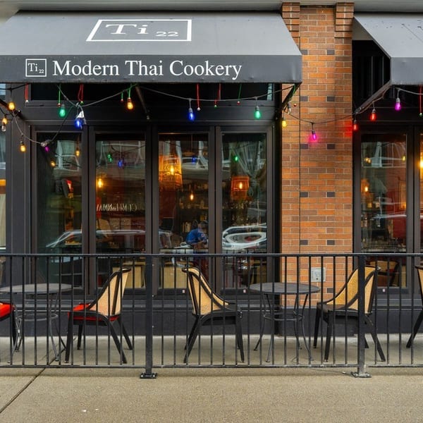Ti 22 Modern Thai Cookery storefront with outdoor seating, black awnings, and colorful string lights.